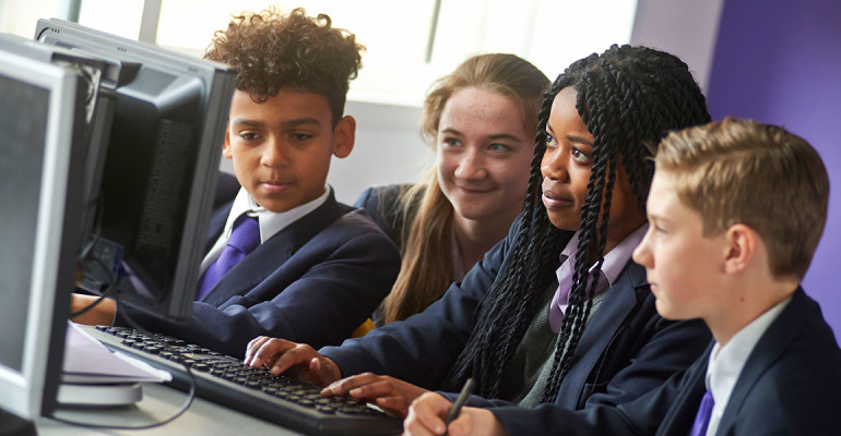 A group of students working on computers in the IT suite