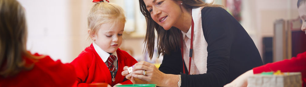 A student and teacher playing with arts and crafts in a classroom