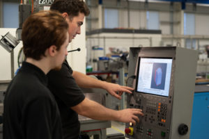 Two students using CAD to create a product in a workshop