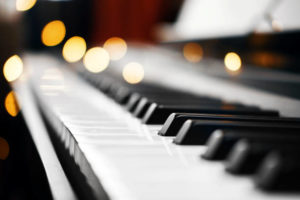 piano keys with Christmas lights in the background