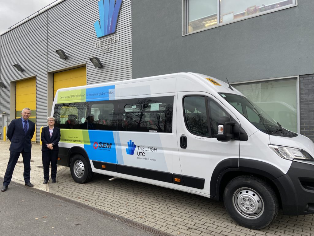 Photo of The Leigh UTC's Principal standing next to another staff member for a photo with the academy's new minibus.