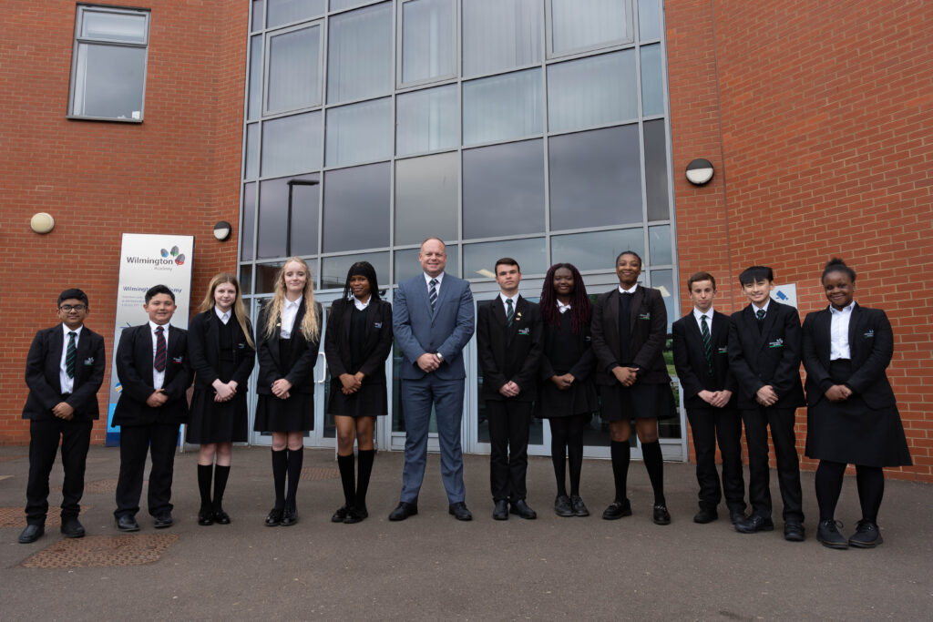 Wilmington Academy students and Principal, Mike Gore stood outside an academy building