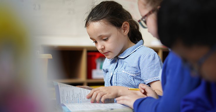 Student reading something on their desk in front
