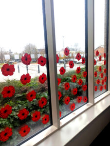 A window pane covered with dozens of red poppy decals.